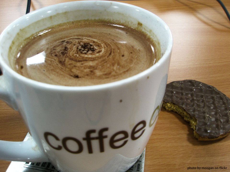 A cup of coffee and a part-eaten biscuit. Yum!